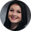 Smiling woman with dark hair in a close-up portrait against a neutral background