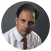 Portrait of a serious man in white shirt and red tie holding glasses against gray background