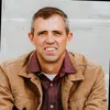 a man wearing a brown jacket