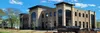 Modern Fayetteville City Hall building with large windows under a blue sky with trees around.