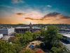 Marietta Downtown cityscape with historic buildings, a central park with a fountain, and a colorful sunset sky.