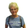 Smiling elderly woman with glasses wearing a blue t-shirt that says Yoga on my mind, pizza in my hand.
