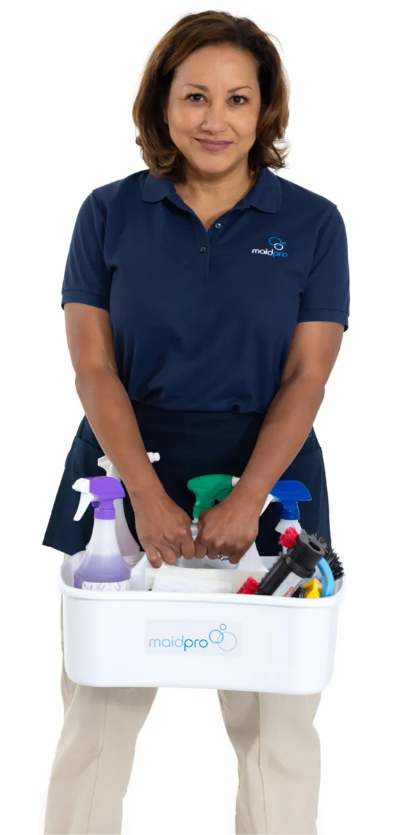 Woman in navy MaidPro uniform holding a white basket with cleaning supplies and tools against white background