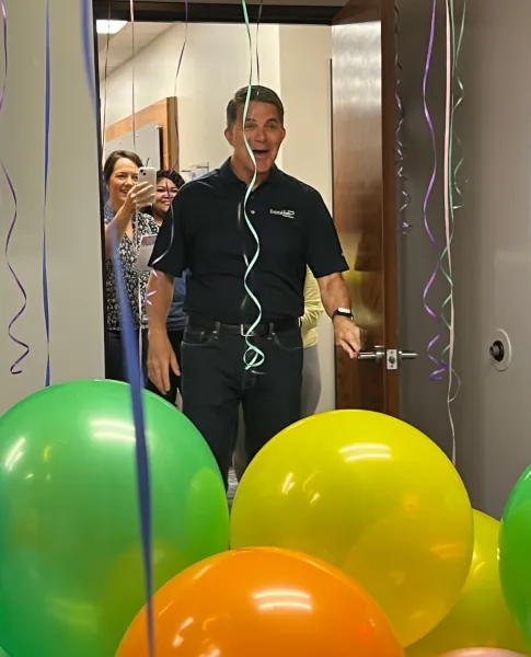 a person wearing headphones and standing next to balloons