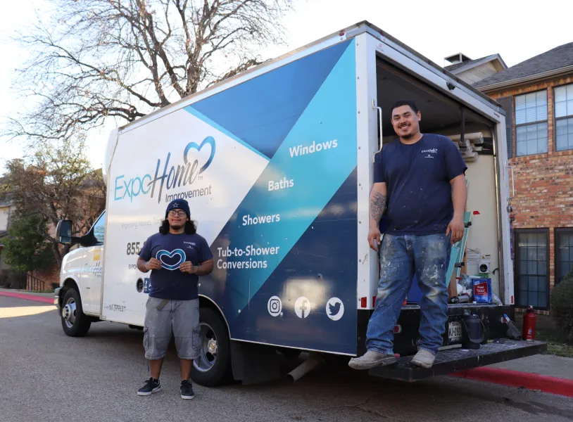 a man and a woman standing next to a truck
