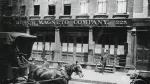 a person riding a horse drawn carriage in front of a building