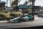 IndyCar race car sponsor One Cure drivers the street circuit with O'Reilly Auto Parts signage and palm trees in background