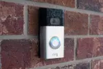 a white and black speaker on a brick wall