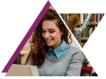 Young woman smiling and working on a laptop with a student browsing books in a library background.