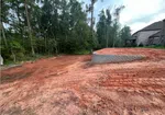 a dirt path with trees on the side