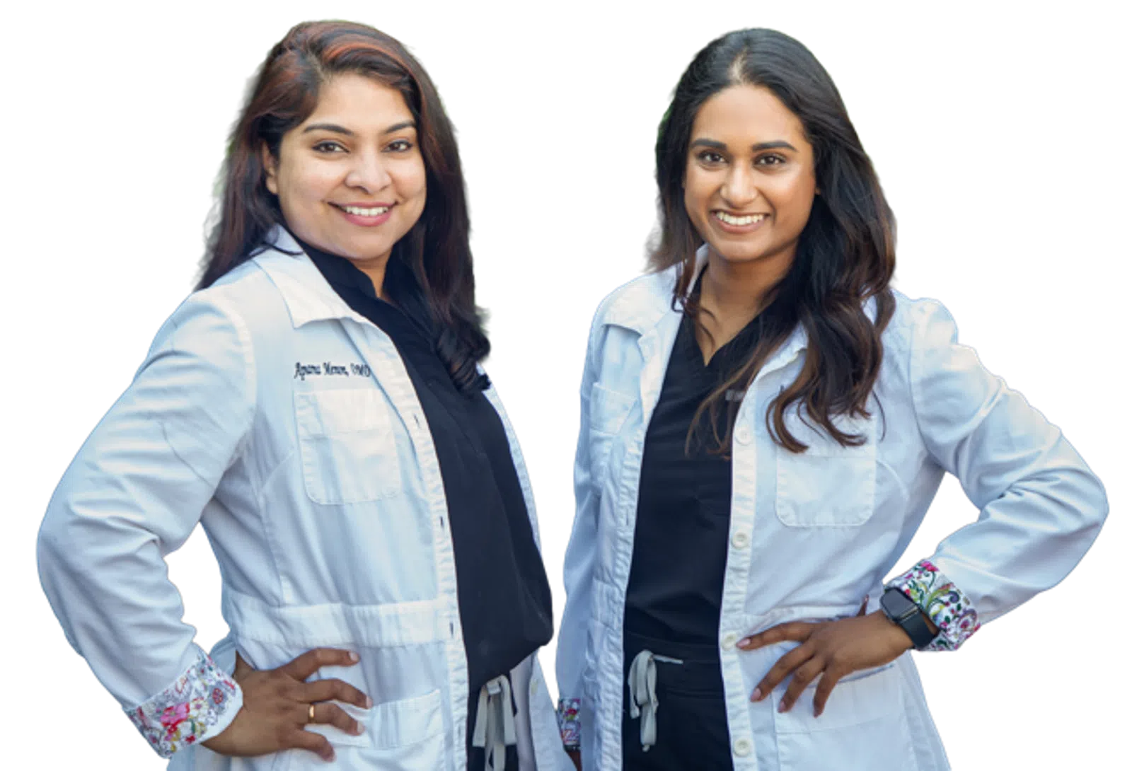 Two smiling female doctors in white coats with hands on hips against a transparent background