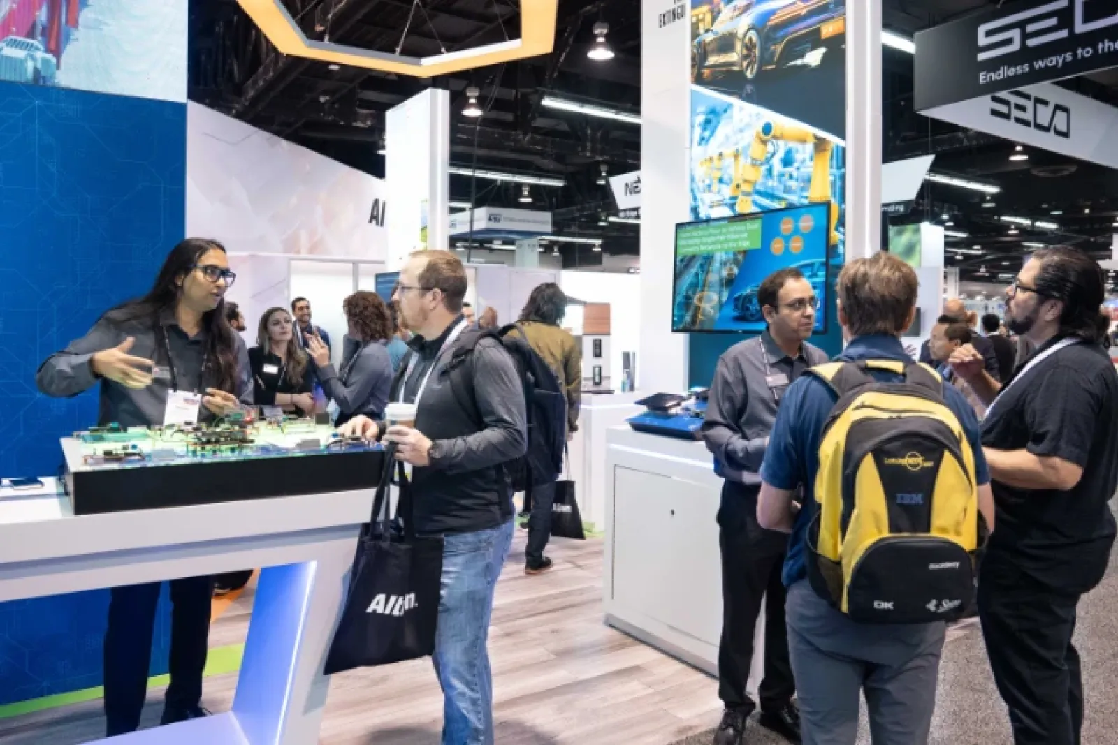 Attendees interact and network at a busy technology and innovation trade show booth indoors