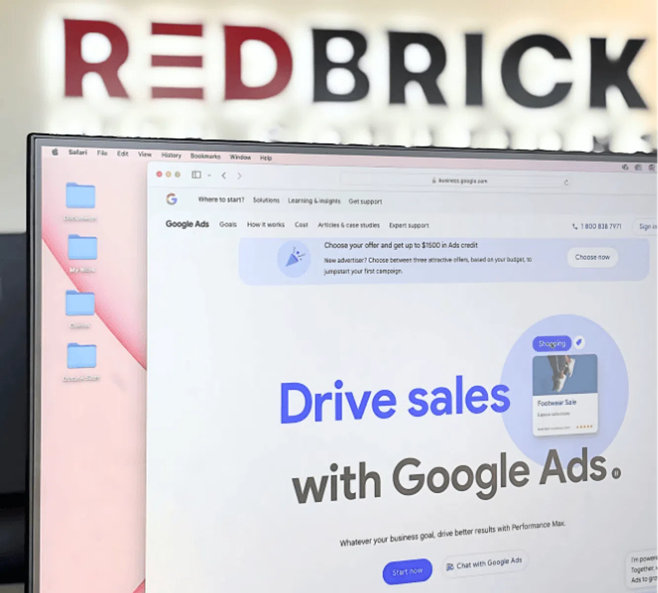 Computer screen displaying Google Ads website with RedBrick logo blurred in the background.