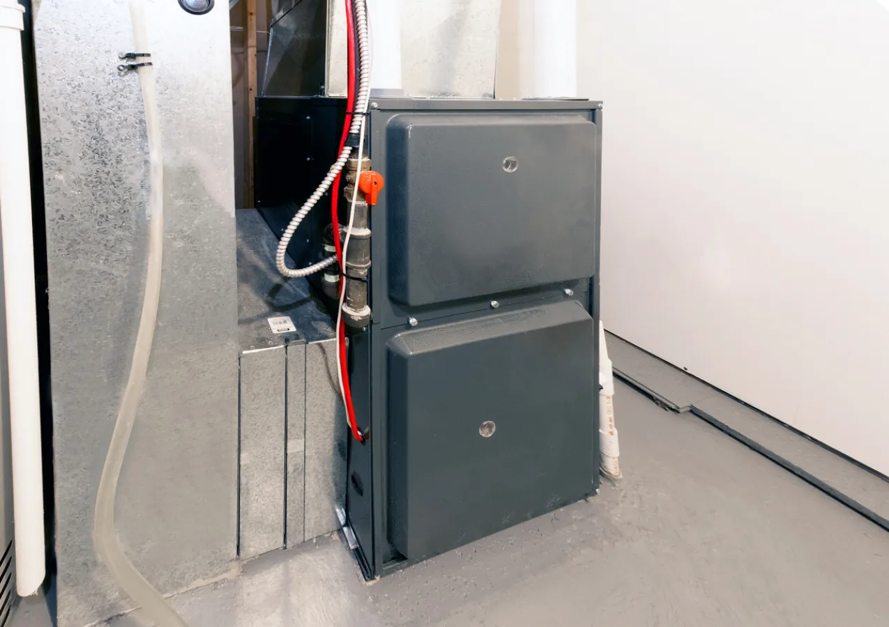 Modern home furnace unit with sleek design and exposed piping in a residential basement setting.