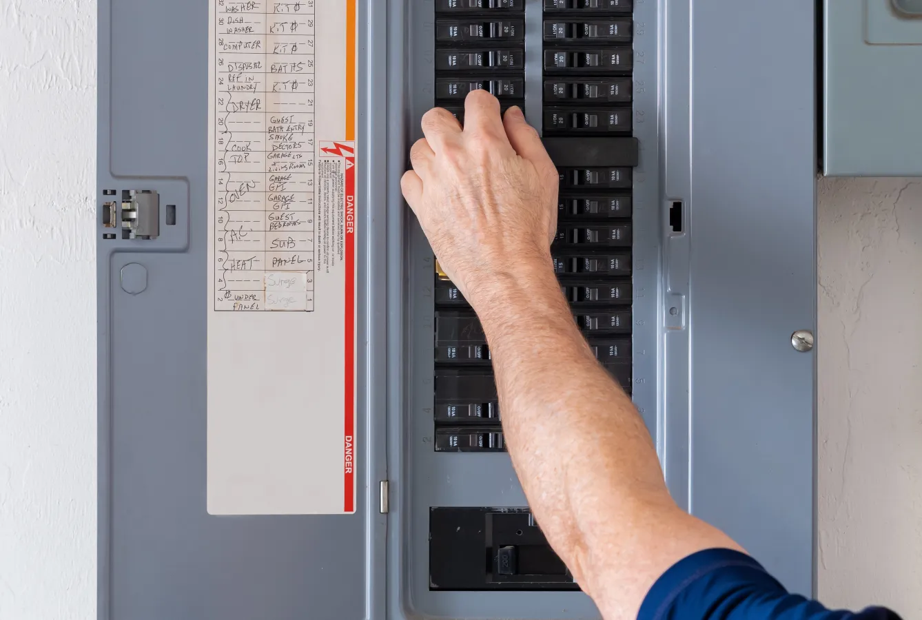 electrician working on panel breaker