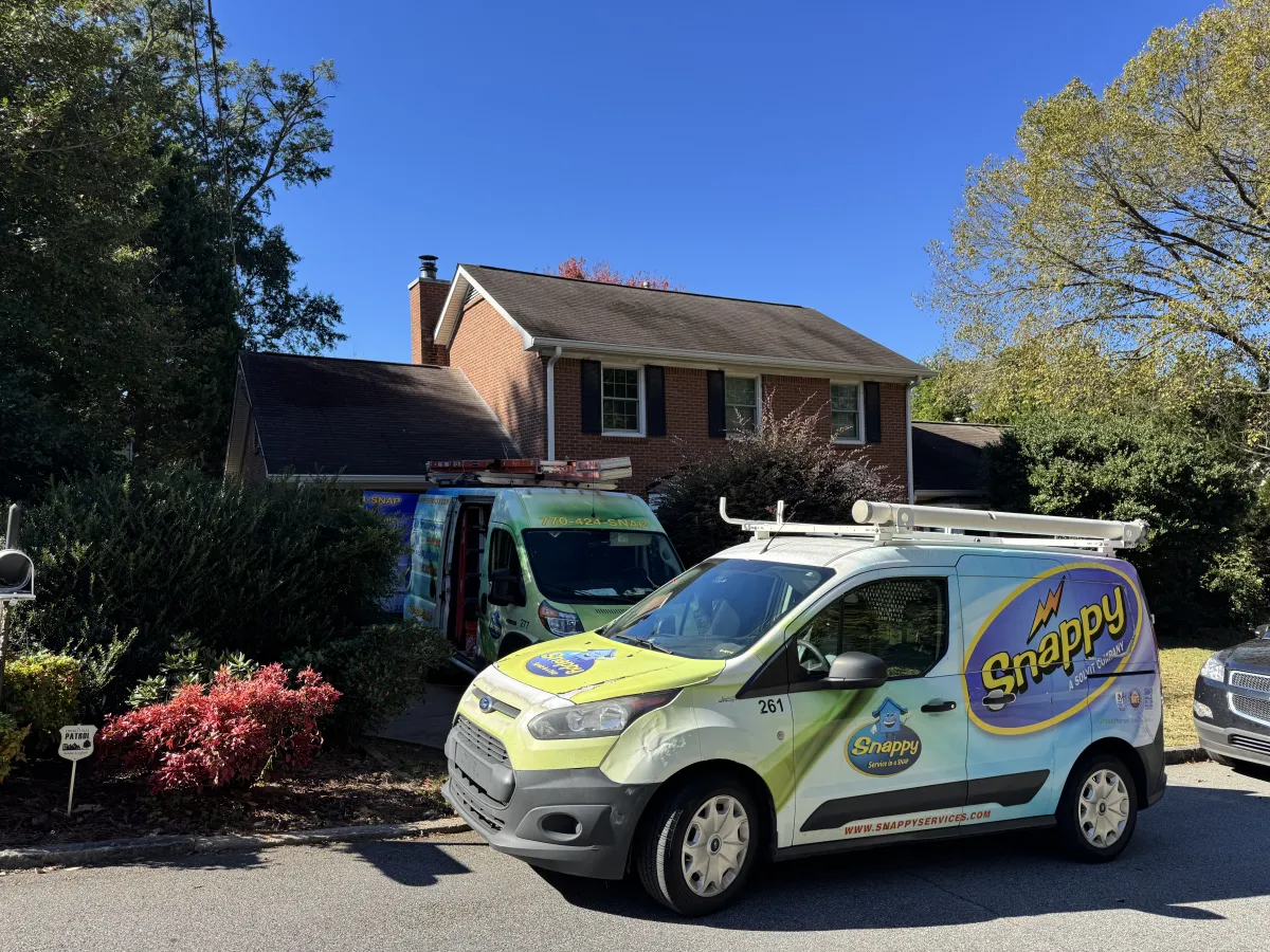 Snappy Services company vans parked outside a residential house on a sunny day with clear blue sky.