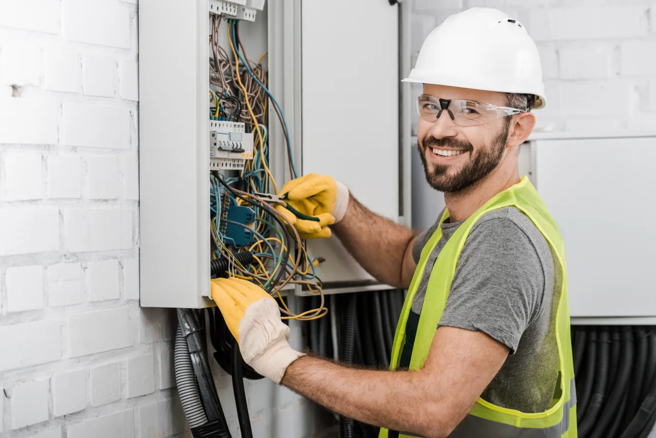 a man wearing a hard hat and safety goggles holding a circuit board