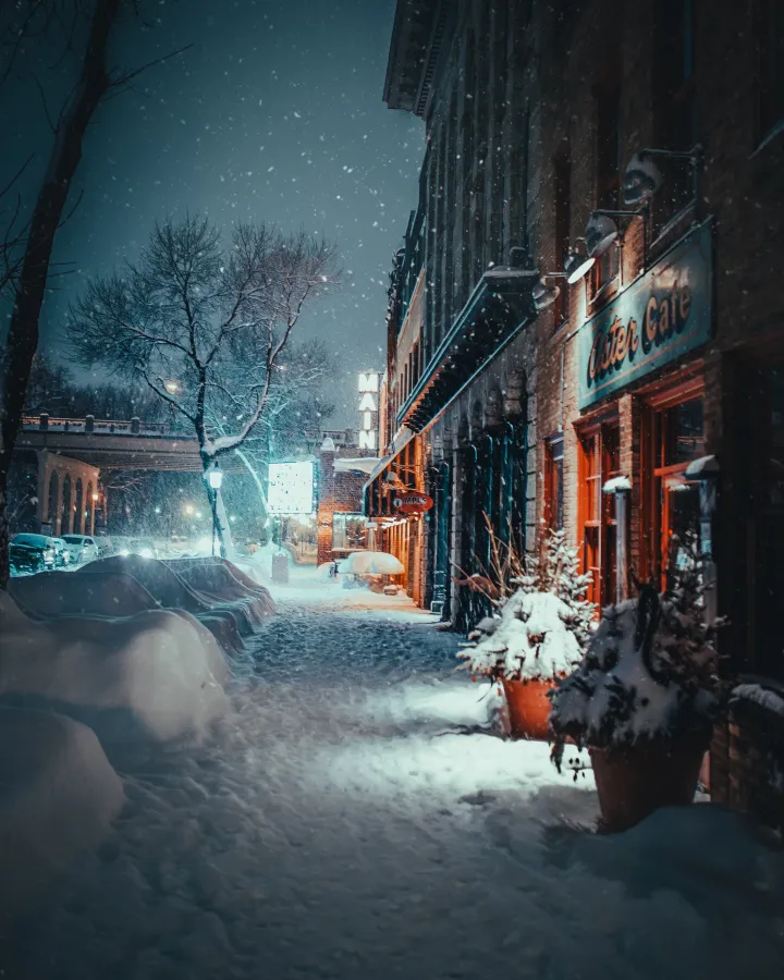 a snowy street with cars and buildings