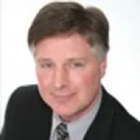 Professional middle-aged man with brown hair wearing a suit and tie against a white background