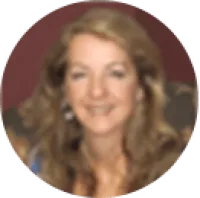Portrait of a smiling woman with long wavy blonde hair and earrings against a blurred background