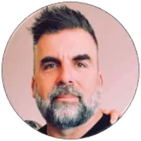 Portrait of a middle-aged man with salt-and-pepper beard and short hairstyle against a neutral background