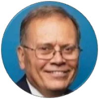 Portrait of a smiling elderly man with glasses against a blue circular background.
