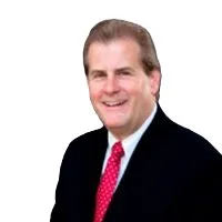 Smiling middle-aged man in a black suit and red tie against a white background