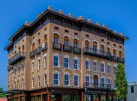 Alpharetta Historic four-story brick building with ornate balconies and large windows under a clear blue sky.