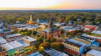 Newnan, GA Aerial view o at sunset showing historic buildings, trees, and church steeples.