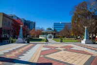 Decatur City plaza with patterned pavement, gazebo, autumn trees, and modern buildings under a clear blue sky