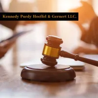 Wooden judge's gavel on desk with blurred background and law firm name Kennedy Purdy Hoeffel & Gernert LLC.
