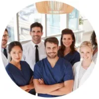 Smiling diverse medical team in scrubs and professional attire in bright modern healthcare setting