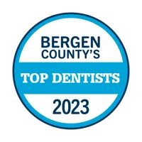 Bergen County's Top Dentists 2023 badge with blue and white circular design.