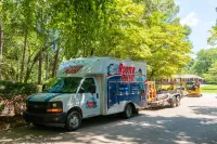 Rooter Plus plumbing service truck with trailer and equipment parked on sunny residential street.