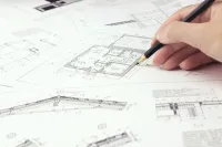 a hand holding a pen over a map