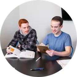 a couple of men looking at a laptop