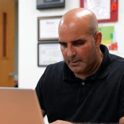 a bald man sitting at a table