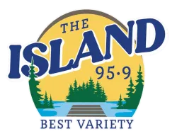 Logo of The Island 95.9 radio station featuring trees, water, and dock under a yellow sky with text Best Variety.