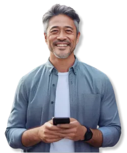 Smiling middle-aged man with gray hair using smartphone wearing casual blue shirt and smartwatch.