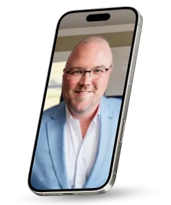 Smiling bald man with glasses wearing blue blazer and white shirt on smartphone screen video call