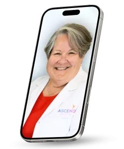 Smiling female doctor with stethoscope holding tablet appearing from smartphone screen, telemedicine concept