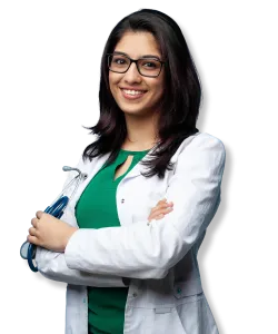 Smiling female doctor with glasses wearing a white coat and holding a stethoscope, arms crossed confidently.