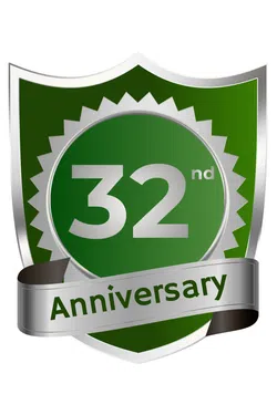 Green and silver shield emblem celebrating a 32nd anniversary with a metallic ribbon banner.