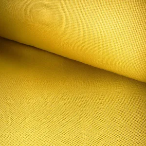 Close-up of bright yellow woven fabric with textured grid pattern in a rolled piece of cloth.