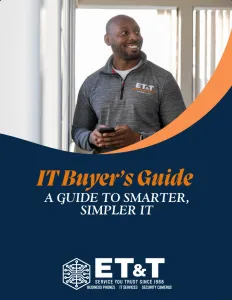 Smiling man in ET&T branded jacket holding phone, with IT Buyer's Guide text and company logo on navy background.