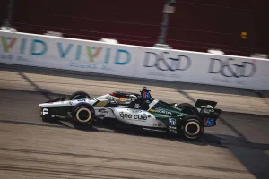 Black and white IndyCar number 15 racing on track with One Cure and Honda sponsorships
