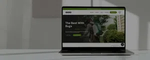 Laptop on table displaying RIDD pest control website with a person using spraying equipment outdoors.
