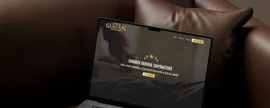 Laptop on brown couch displaying Lubbock General Contractors website with dark theme and gold accents.