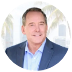 Professional middle-aged man in blue suit with city skyline and palm trees in the blurred background