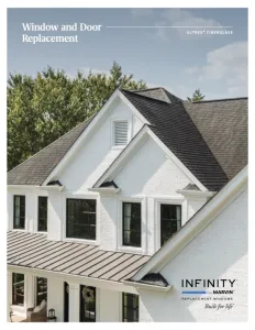 White brick house with black framed replacement windows and dark shingled roof under a blue sky.